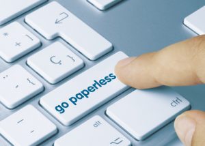 computer kepboard with a finger pointing to a "go paperless" button
